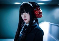 a woman with long black hair wearing a red headband and a creepy mask on her face