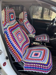 the interior of a car with crocheted seat covers and matching cushions on it