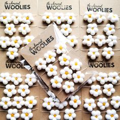 some white and yellow flowers are on top of brown paper with words that read the meaning of woolies