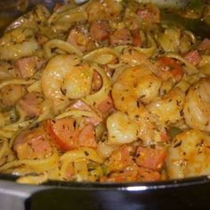 pasta with shrimp and tomato sauce in a black pot on the stove top, ready to be cooked