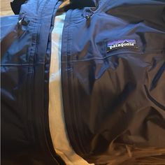 Never Worn Patagonia Navy Blue Rain Jacket Navy Casual Outerwear For Travel, Navy Travel Outerwear With Pockets, Blue Travel Outerwear With Pockets, Blue Winter Windbreaker For Travel, Winter Travel Blue Windbreaker, Blue Winter Travel Windbreaker, Blue Long Sleeve Windbreaker For Travel, Navy Waterproof Nylon Windbreaker, Patagonia Rain Jacket