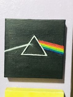 a piece of art with a rainbow triangle painted on it