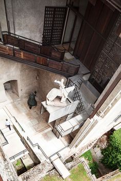 an aerial view of a building with stairs and statues on the outside, looking down