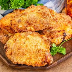 some fried food on a wooden plate next to drinks