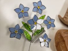 a blue and white stained glass flower on a stand