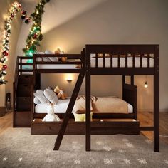 there is a bunk bed in the room with christmas decorations on the wall and lights around it