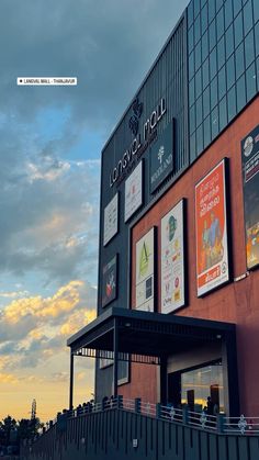 the outside of a building with posters on it's side and sky in the background