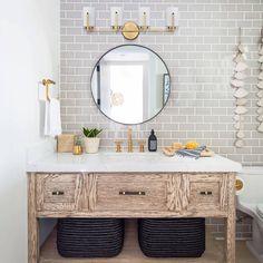 a bathroom with a sink, mirror and two baskets on the counter in front of it