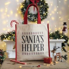 a santa's helper bag sitting on top of a table next to a christmas tree