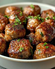 meatballs with sauce and parsley in a white bowl