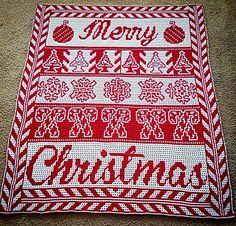 a red and white knitted christmas blanket with merry written on it