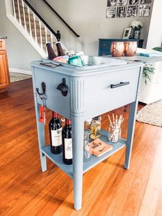 a blue table with bottles and glasses on it in the middle of a living room