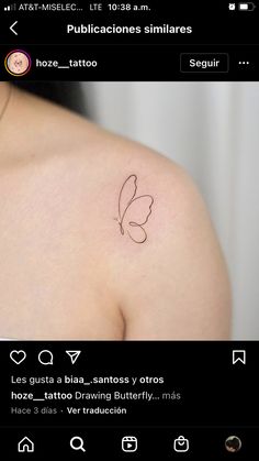 a small butterfly tattoo on the back of a woman's shoulder