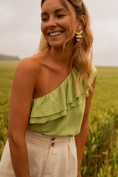 Get ready to turn heads with the Green Moby Top! This stunning one shoulder-asymmetrical top features exquisite double ruffles on the chest and a beautiful linen effect. It's unlined, making it perfect for any occasion or season! Our model wears the beige Alec shorts Sizes: S-M/M-L S-M: Length 21.3 in - Width 15.4 in M-L: Length 22.4 in - Width 16.5 in 70% Viscose - 30% Linen / Lining: 100% Viscose Washing: Handwash Couple Style, Asymmetrical Tops, Fashion Couple, Summer Jewelry, Summer Season, Women's Style, Summer Women, Statement Pieces, Best Sellers