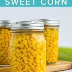 two jars filled with corn sitting on top of a table