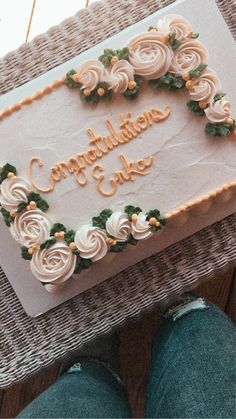 there is a cake that says congratulations cake on the table next to someone's feet