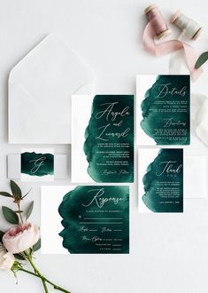 the wedding stationery is set up with green watercolor paint