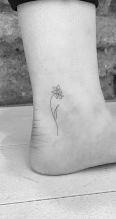 a small flower tattoo on the ankle