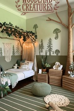 a bedroom decorated in green and white with trees painted on the walls, bedding and rugs