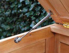 a close up of a wooden bench with a metal handle on it's end