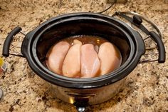 two raw chickens in a pot on the stove