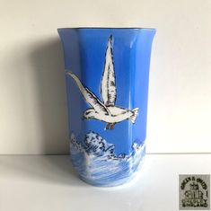 a blue vase with a seagull painted on it