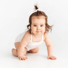 a baby girl in a diaper crawling on her stomach