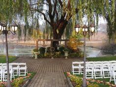 an outdoor ceremony setup with white chairs and lights