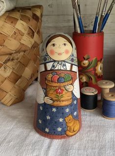 a wooden doll next to some spools of thread