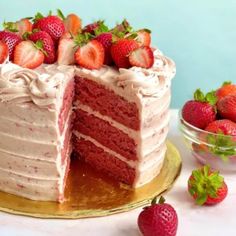 there is a cake with strawberries on the top and one slice missing from it