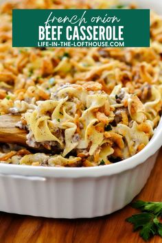 a casserole dish filled with beef, cheese and parsley in a white baking dish