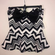 This Polyester/Spandex Blend Top Is Strapless, With A Semi-Sweetheart Neckline. The Adorable Black Bow Takes Center Stage And Compliments The Black And White Geometric Pattern Of The Whole Thing. Nwt Trendy White Tube Top For Party, Black Sleeveless Tube Top For Day Out, Sleeveless Black Tube Top For Day Out, Black Tube Top For Day Out, Fitted Black And White Tops For Party, Fitted Black And White Party Tops, Strapless Peplum Top, Black And White Geometric Pattern, Tan Tank Top