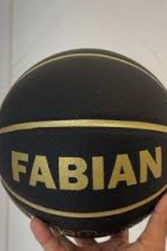 a close up of a basketball being held by a person's hand with the word fabian on it