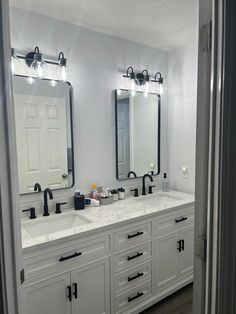 a bathroom with double sinks and two mirrors