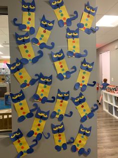 the bulletin board is decorated with blue and yellow paper cut out of cat's legs