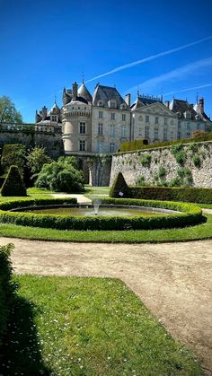 a large castle with a fountain in the middle of it's courtyard and landscaping