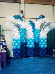 some blue and white balloons are in the shape of dolphins