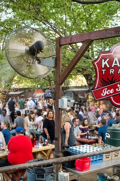 a large group of people sitting at tables in front of a sign that says kale trae