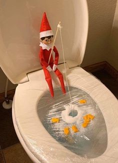 an elf is on top of the toilet