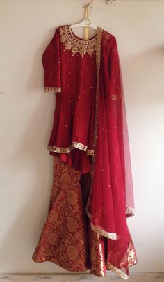 a red and gold wedding dress hanging on a wall