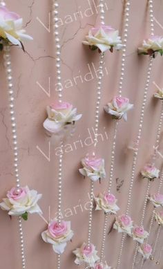 the wall is decorated with pearls and pink roses on it's sides, along with beads