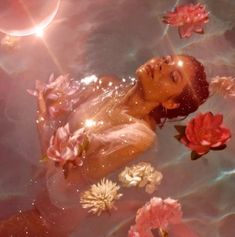 a woman floating in the water surrounded by flowers