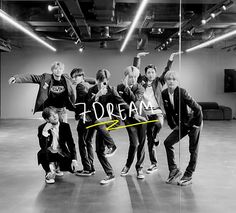 a group of young men standing next to each other in front of a wall with the word dream written on it