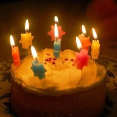 a birthday cake with lit candles on it