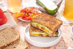 a sandwich cut in half sitting on top of a white plate next to two slices of bread