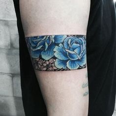 a blue rose tattoo on the left arm