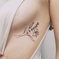 a woman with a flower tattoo on her left side ribcage and breast area