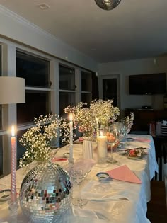 the table is set with flowers and candles