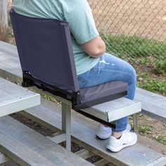 a woman sitting on top of a wooden bench