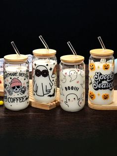 four decorated mason jars sitting on a table